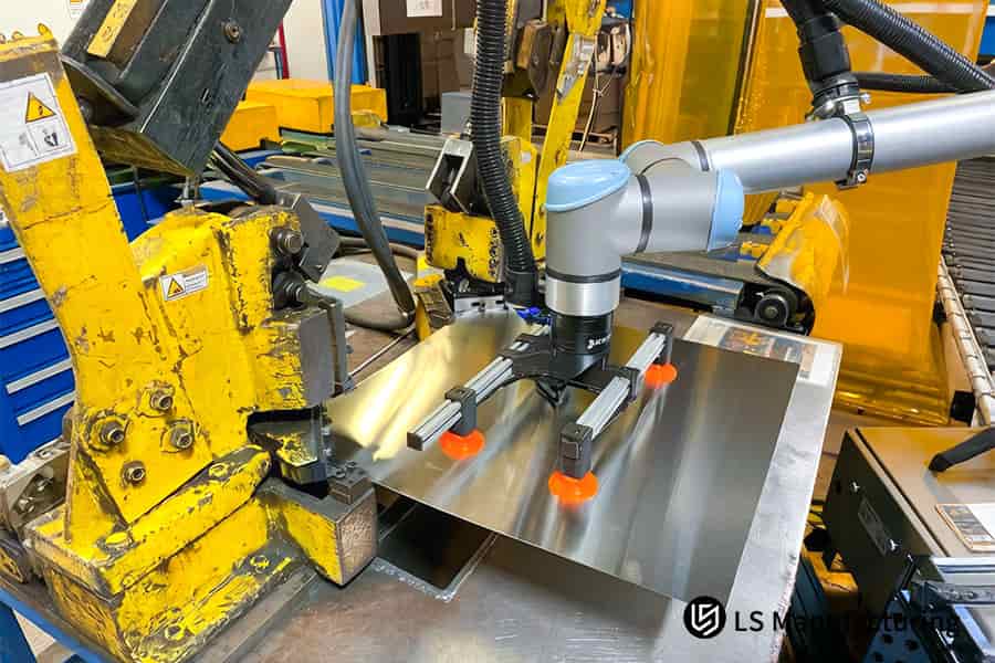 Le ventose robotizzate arancioni posizionano lamiere di acciaio ASTM 304 per lo stampaggio ad alta velocità di parti personalizzate.